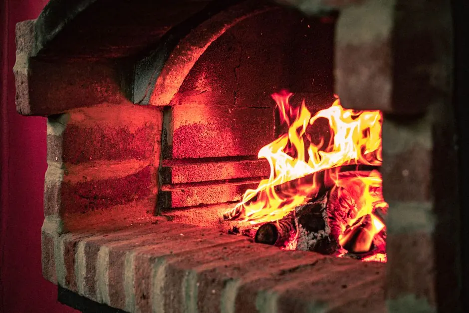 Warm brick oven fireplace with a glowing fire, showcasing vibrant flames and rustic masonry.